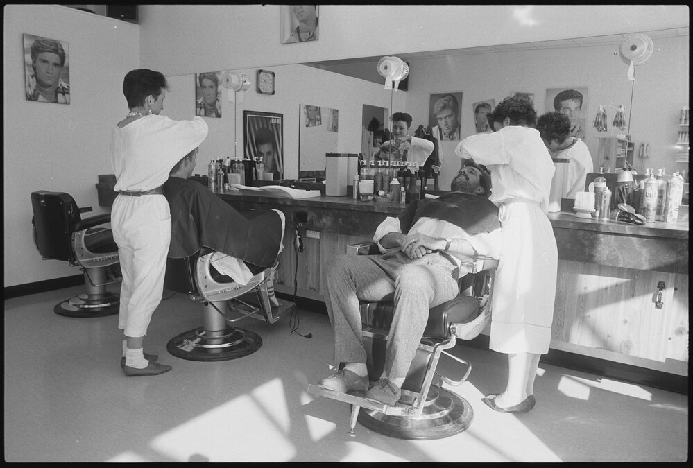 Unidentified hairdressers working at a barber shop, Ipswich, July 1985