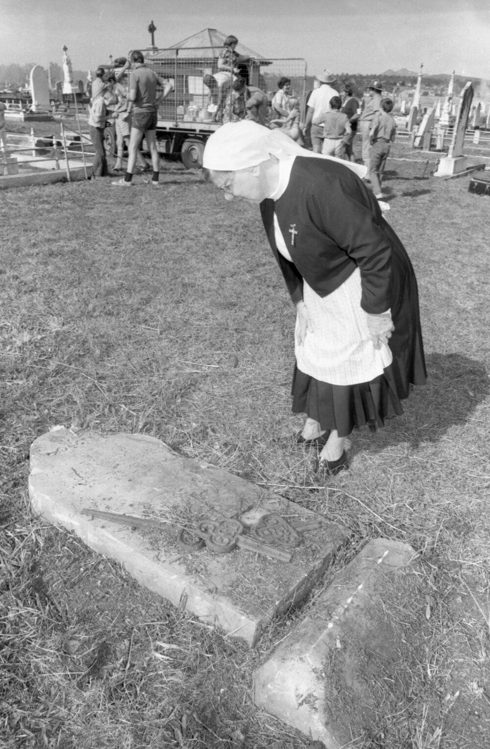 Nun reading inscription on fallen headstone during Ipswich General Cemetery 'Clean-Up' campaign, Ipswich, 18th June 1977