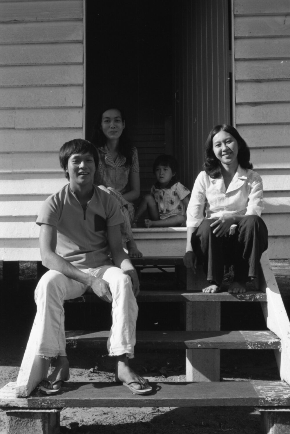 Unidentified family sitting on steps, Ipswich, November 1977