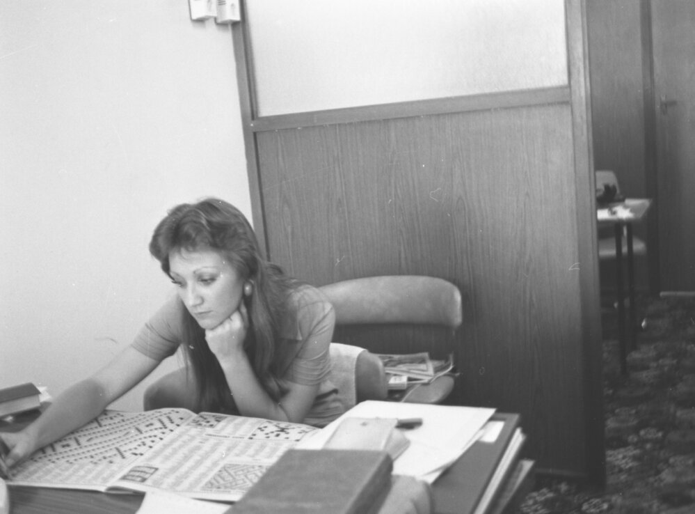 Unidentified woman doing crosswords in an office, Ipswich, November 1977