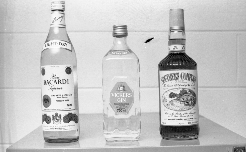 Bottles of Bacardi Rum, Vickers Gin, and Southern Comfort whiskey liqueur, photographed for advertisements in the Queensland Times, Ipswich, Queensland, February 1978