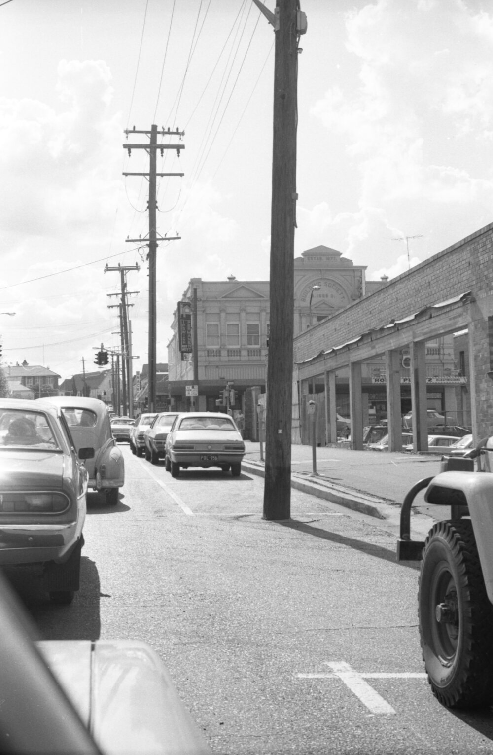 Power poles and traffic, Limestone Street, Ipswich, Queensland, February 1978