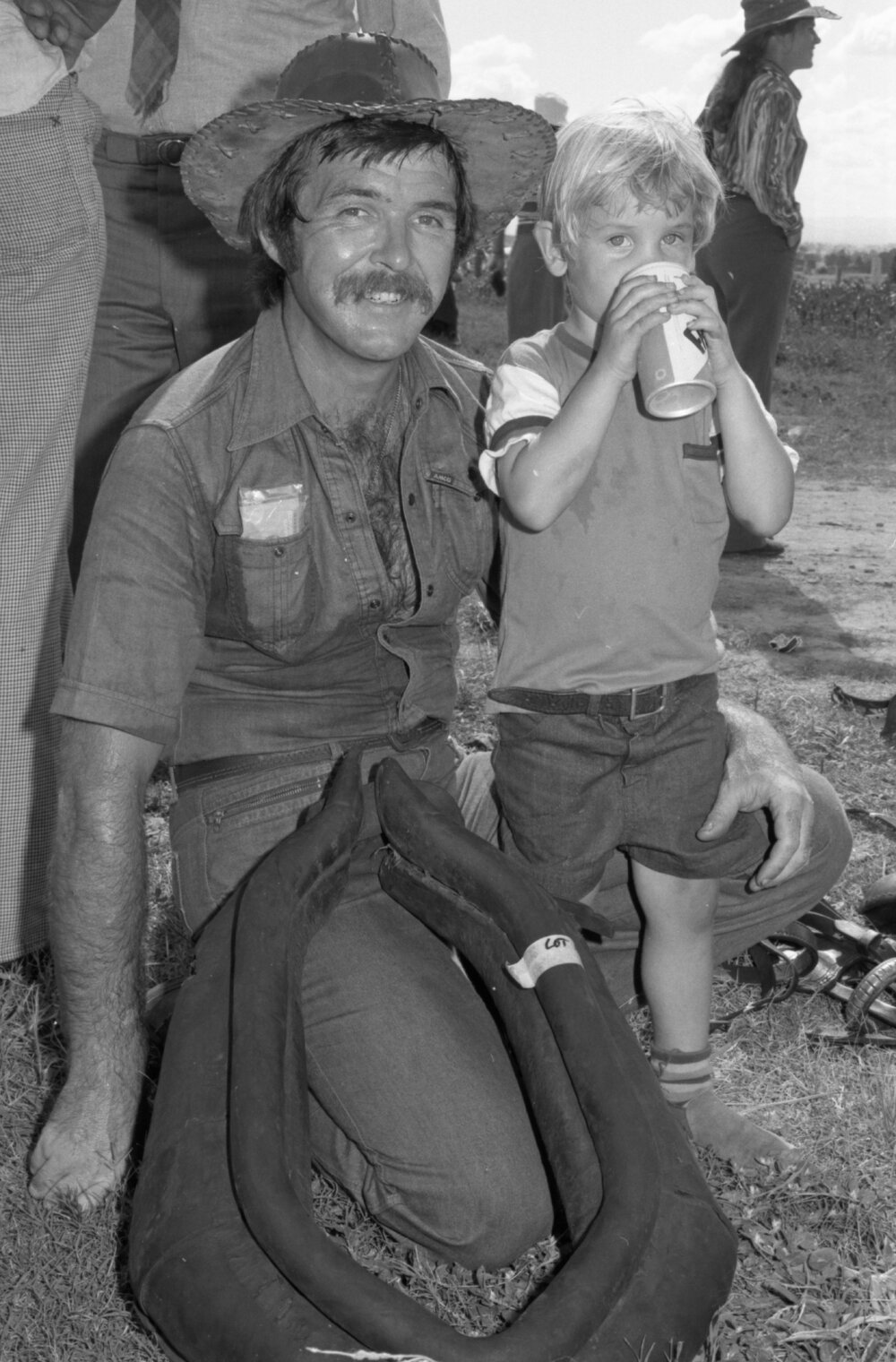 Unidentified man and boy with a horse collar for sale at an unidentified horse event, Ipswich, February 1978