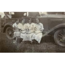 Four unidentified women sitting on running board of car, Booval, Ipswich, 1920s