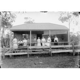 Group standing on veranda of St Mungo, thought to be a holiday home at Margate, Moreton Bay, 1900s