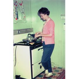 Woman cooking in kitchen of home at 7 Alice Street, Blackstone, Ipswich, 1963