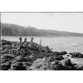 Unidentified group of boys fishing on rocks at Woody Point, Redcliffe, 1900s