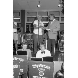 Ipswich Beardies awarding a cheque to the Ipswich Vice-Regal Model Band on the Ipswich Vice-Regal Model Band stage at Booval Fair during the Ipswich Colour Festival, Booval, August 1980