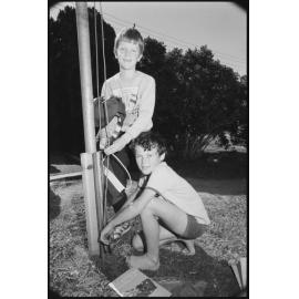 Two unidentified boys raising an Australian Flag on a flag pole, Ipswich, September 1987