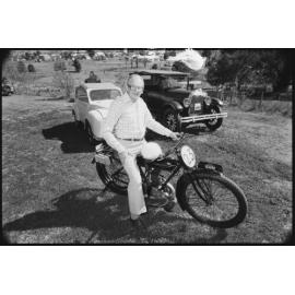 Unidentified man riding 1916 Sun motorcycle with 1926 Willys-Overland Whippet 2 Door Sedan car and 1951 Hartnett Pacific car, Ipswich, September 1987