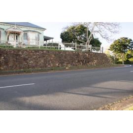 Retaining wall and above ground pipe in front of 'Caloola', former home of Mayor John Macfarlane, 1 Deebing Street, Ipswich, September 2022