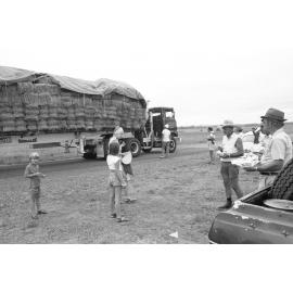 Volunteers take lunch after harvesting hay from RAAF Base Amberley for starving cattle in Toogoolawah, Amberley, Ipswich, Queensland, January 1978