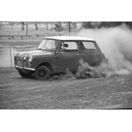 Man driving Morris Mini-Minor down dirt track, Ipswich, Queensland, January 1978