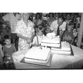 Woman cutting cake at the Grandchester State School centenary celebration, Grandchester, Ipswich, January 1978