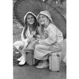 Girls with raincoats and umbrella in the rain, Ipswich, January 1978