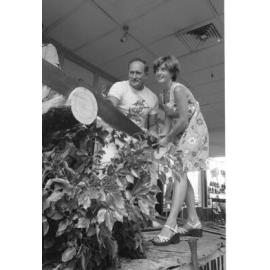 Unidentified man in Canungra shirt demonstrates long saw with audience member at Booval Fair, Booval, Ipswich, February 1978