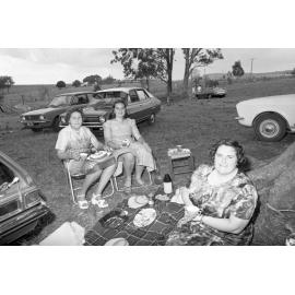 Women eating cake while picnicking, Ipswich, November 1977