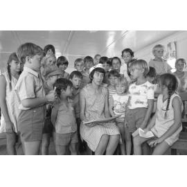Unidentified woman in sailor hat reading to a group of children for a Church of Christ program, Ipswich, February 1978