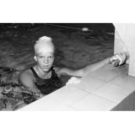Unidentified swimmer wearing a swimming cap at a starting block in a pool, Ipswich, Queensland, February 1978
