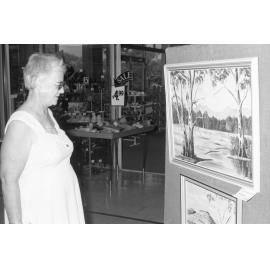 Woman admiring artwork outside a shoe store, Ipswich, Queensland, 15th February 1978