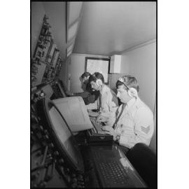 Three unidentified RAAF Airmen operating a control board, Ipswich, July 1985