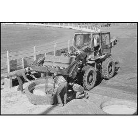 Unidentified people moving concrete garden bases with a Michigan Loader 35B most likely at the Gatton Show Grounds, Gatton, July 1985
