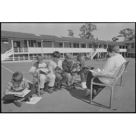 Unidentified students and teacher reading in an outside class, Ipswich, July 1985