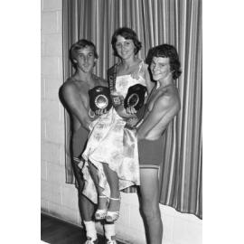 Unidentified wrestlers holding the 1977 Miss Queensland Amateur Wrestling Queen, Ipswich, November 1977