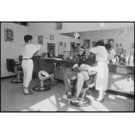 Unidentified hairdressers working at a barber shop, Ipswich, July 1985