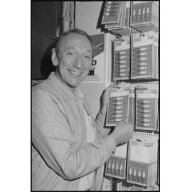 Man in shop with display of Bosch spark plugs and SAAS steering wheels, July  