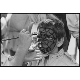 Unidentified young boy having his face painted, Ipswich, July 1985