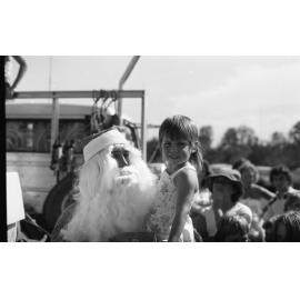 Santa giving unidentified girl a gift, Ipswich, December 1979