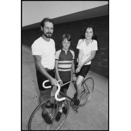 Unidentified man, boy, and girl with racing bicycle in car park outside the Queensland Times office, West Ipswich, January 1986