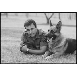 RAAF Serviceman Reynolds relaxing with RAAF Service Dog at RAAF Base Amberley, Amberley, Ipswich, January 1986