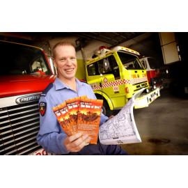 Tim Morris holding bush fire news pamphlets, Ipswich, December 2003