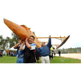 People carrying an outrigger to the lake's edge for launching, Ipswich, December 2003
