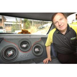 Daryl Neumann of Autobarn Ipswich demonstrating the three, 10-inch Rockford sub-woofers in his car at car show, Rosewood, September 2003