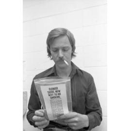 Unidentified man smoking with sunflower seed packet encouraging quitting smoking, Ipswich, September 1980