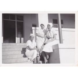 Nurses J. Kerle, Sue Gardiner and Gloria Young sitting on steps of Trumpy House, Ipswich Hospital, 1950s