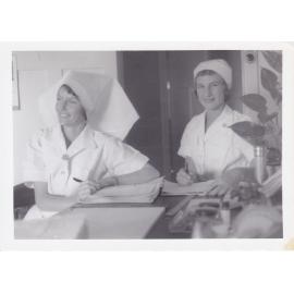Nurses J Donald and R Herman completing documentation in ward, Ipswich Hospital, Ipswich, 1950s