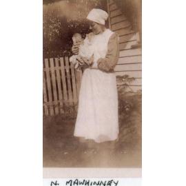 Nurse M A Whinney with baby in grounds, Ipswich General Hospital, c1920