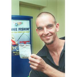 Unidentified man holding a jackpot ticket, Ipswich, February 2003