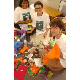 Three unidentified women organising craft supplies for international women's day, Ipswich, March 2003