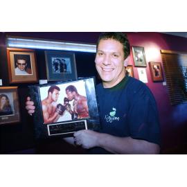 Jason Davidson from Fig Jam Cafe, showing off the cafe's art display, Ipswich, April 2003