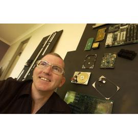 Michael Flynn in front of a wall of motherboards, Ipswich, November 2003