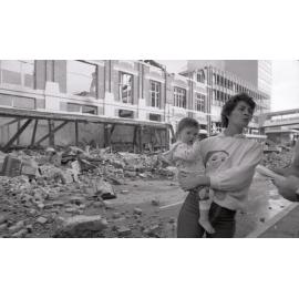 Mother and child view the aftermath of the Reid's (Cribb & Foote) fire, Bell Street, Ipswich, August 1985