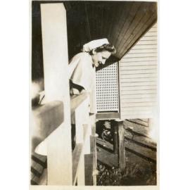 Nurse on verandah of wooden building, 1940s