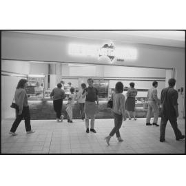 Unidentified people in front of the Redbank Plaza Shopping Centre The Great Australian Pie Company during the grand opening, Redbank, September 1985