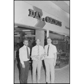 Unidentified men in front of Redbank Plaza Shopping Centre Day & Grimes Furniture store during grand opening, Redbank, September 1985