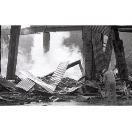 Man inspecting the aftermath of the Reid's (Cribb & Foote) fire, Bell Street, Ipswich, August 1985
